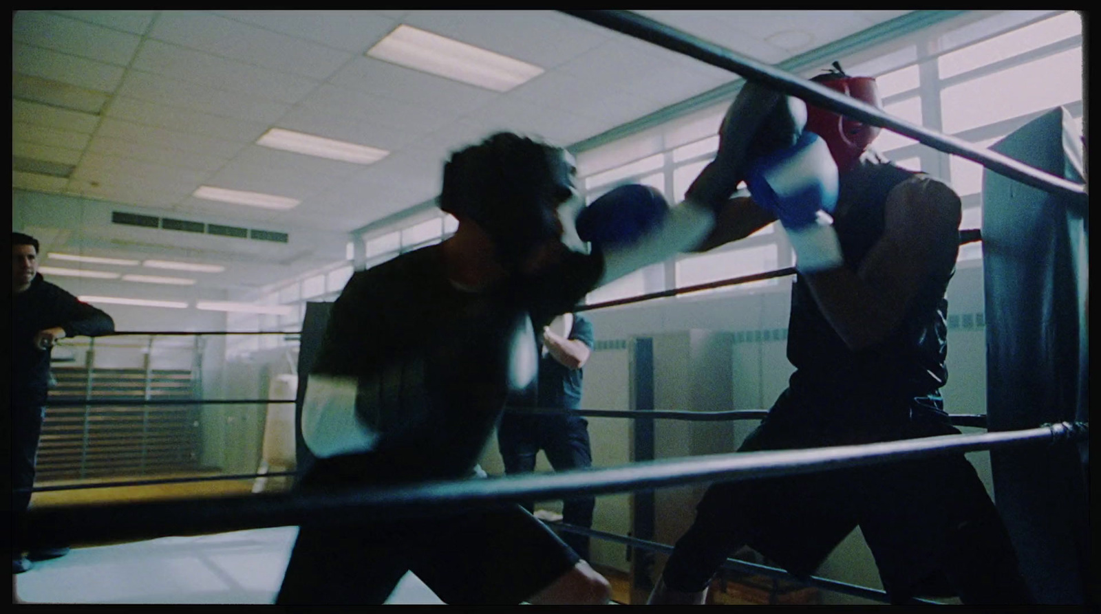 a couple of men standing next to each other near a boxing ring