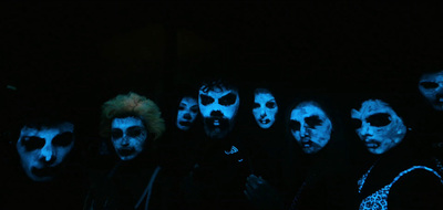 a group of people with painted faces in the dark