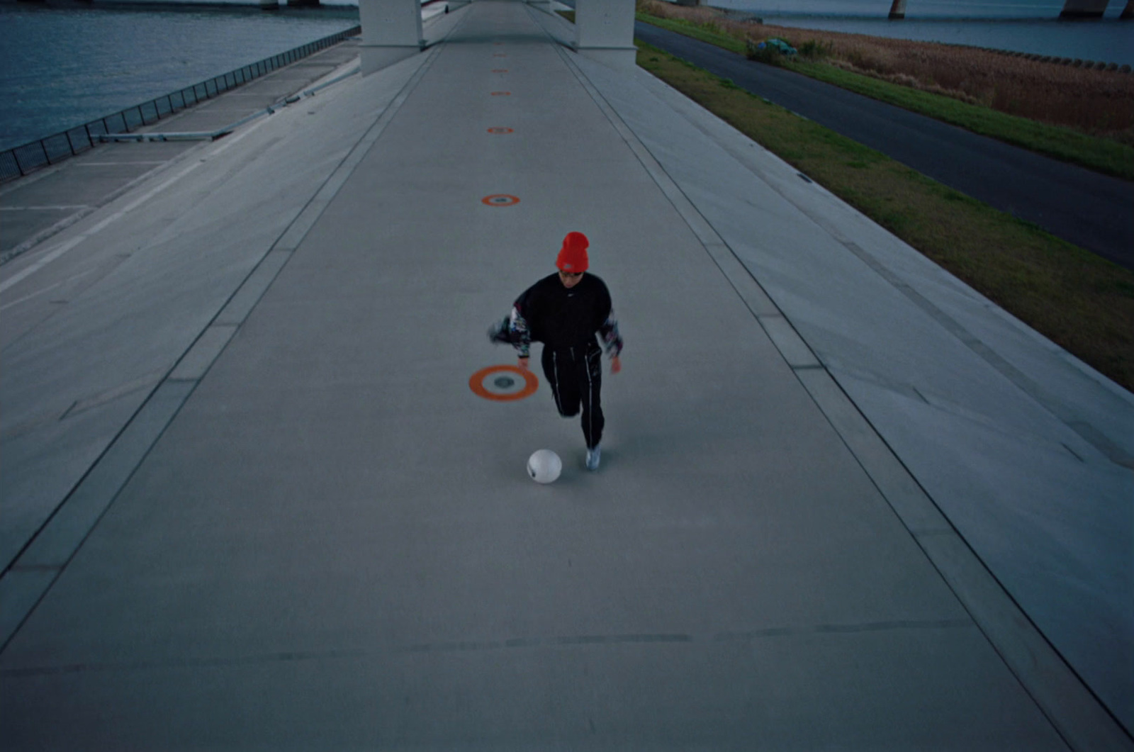 a person in a red hat kicking a soccer ball