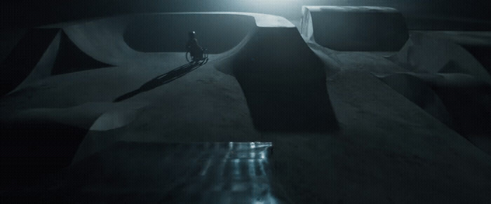 a person riding a skateboard down a ramp in the dark