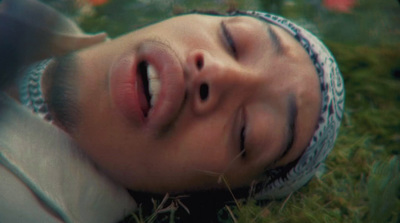 a man laying in the grass with his eyes closed