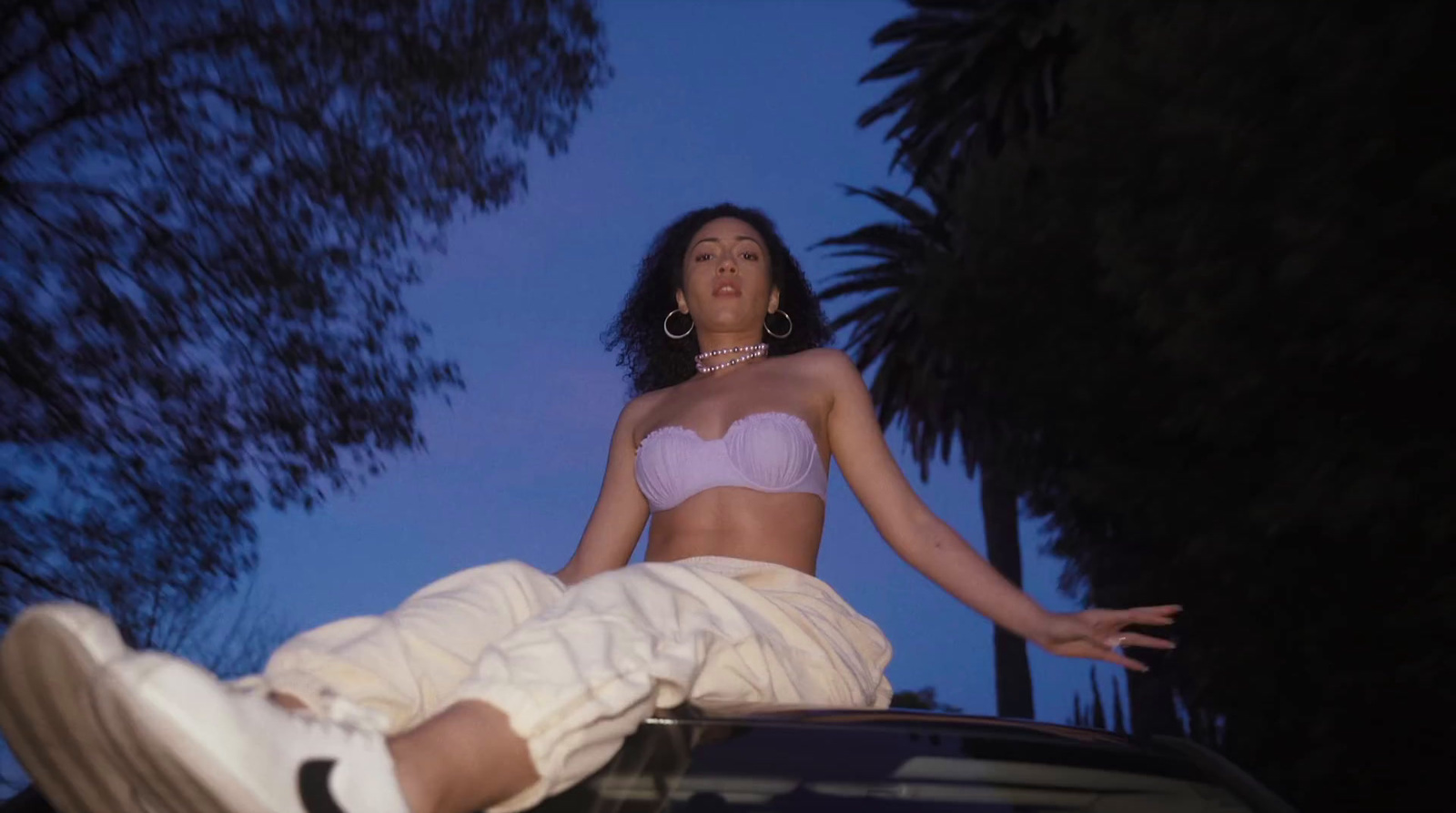 a woman sitting on the hood of a car