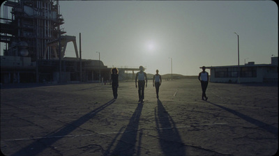 a group of people walking across a parking lot