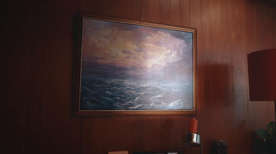 a painting hanging on a wall next to a lamp