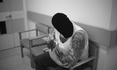 a man sitting in a chair with a tattoo on his arm