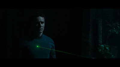 a man standing in the dark with a green laser in his hand