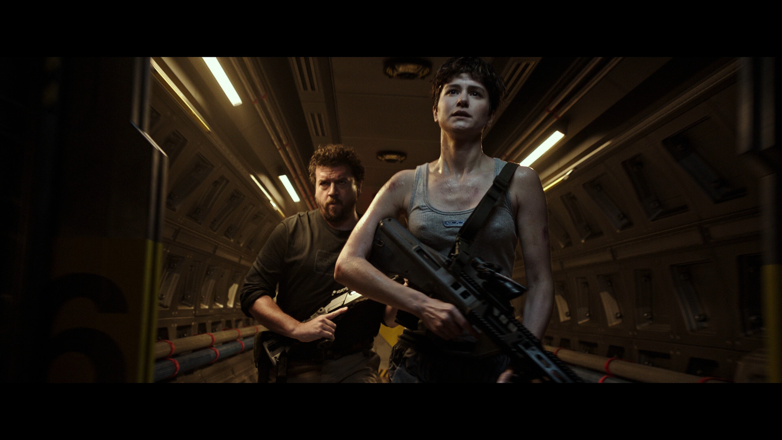 a man and a woman holding guns in a hallway