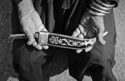 a black and white photo of a person holding a knife