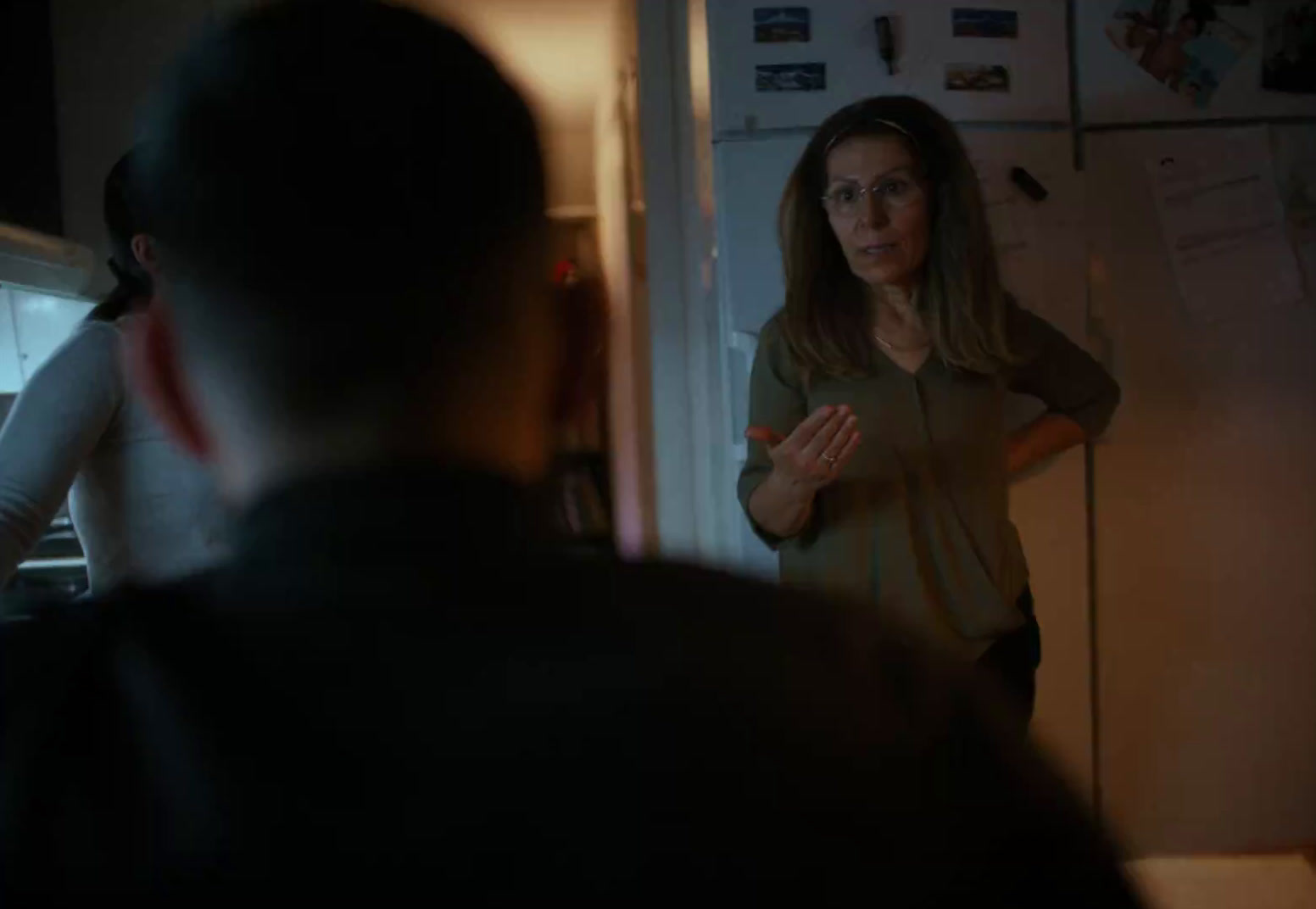 a woman standing in front of a refrigerator in a kitchen