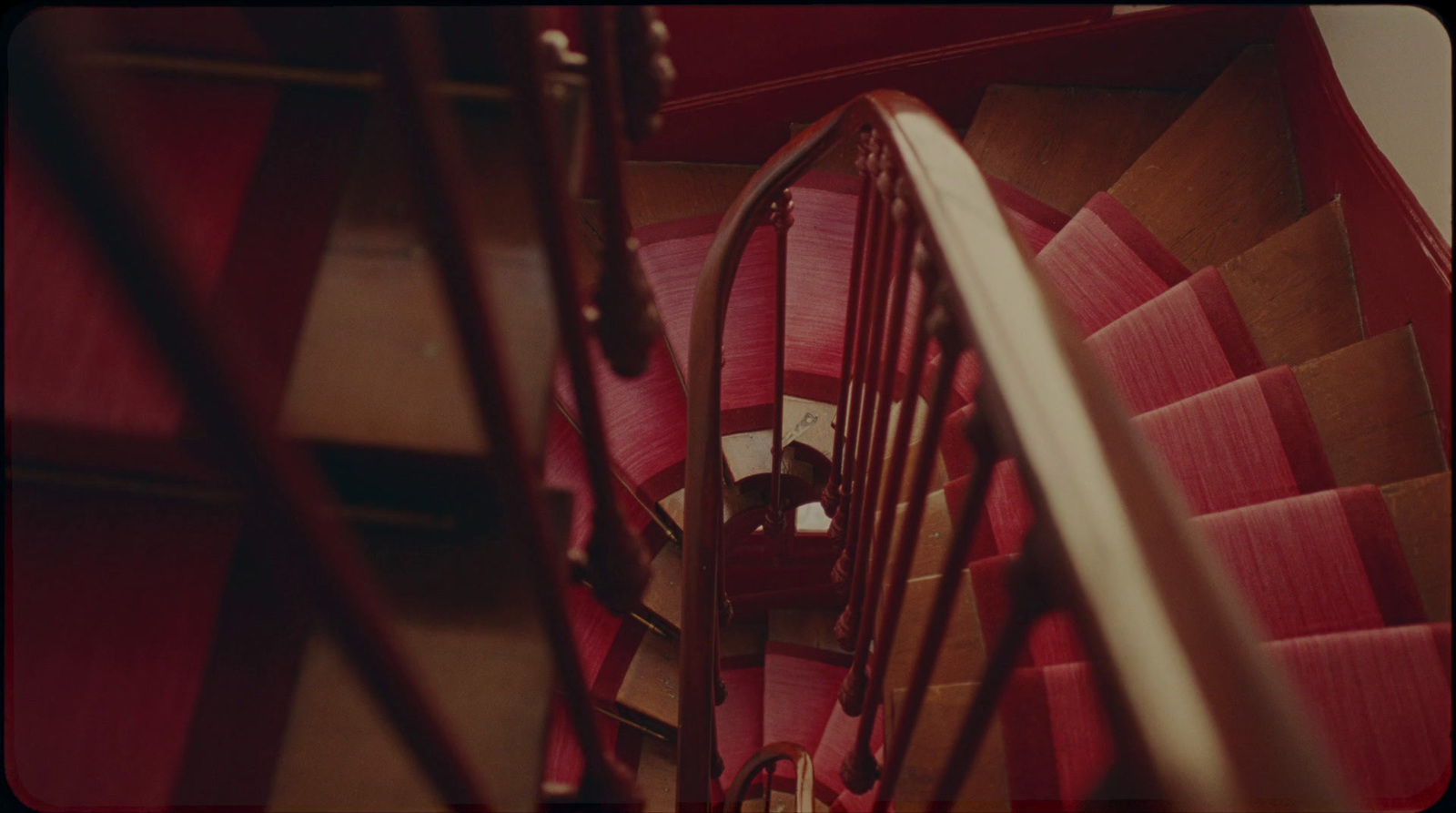 a red staircase with a wooden hand rail