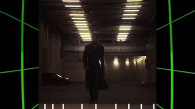 a man in a long coat walking through a tunnel