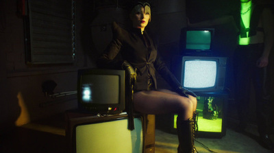 a woman sitting on a chair in front of tvs