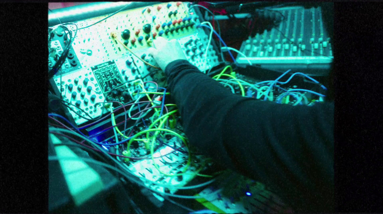 a person working on a computer surrounded by wires