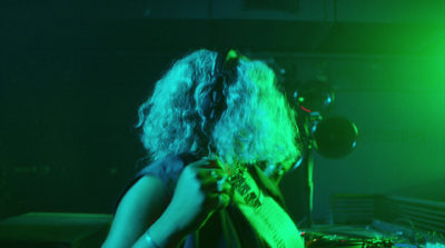 a woman with curly hair playing a guitar