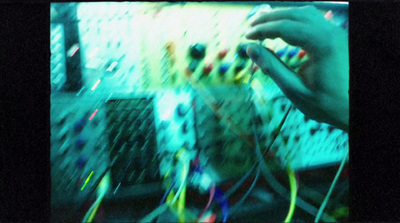 a person working on a computer surrounded by wires