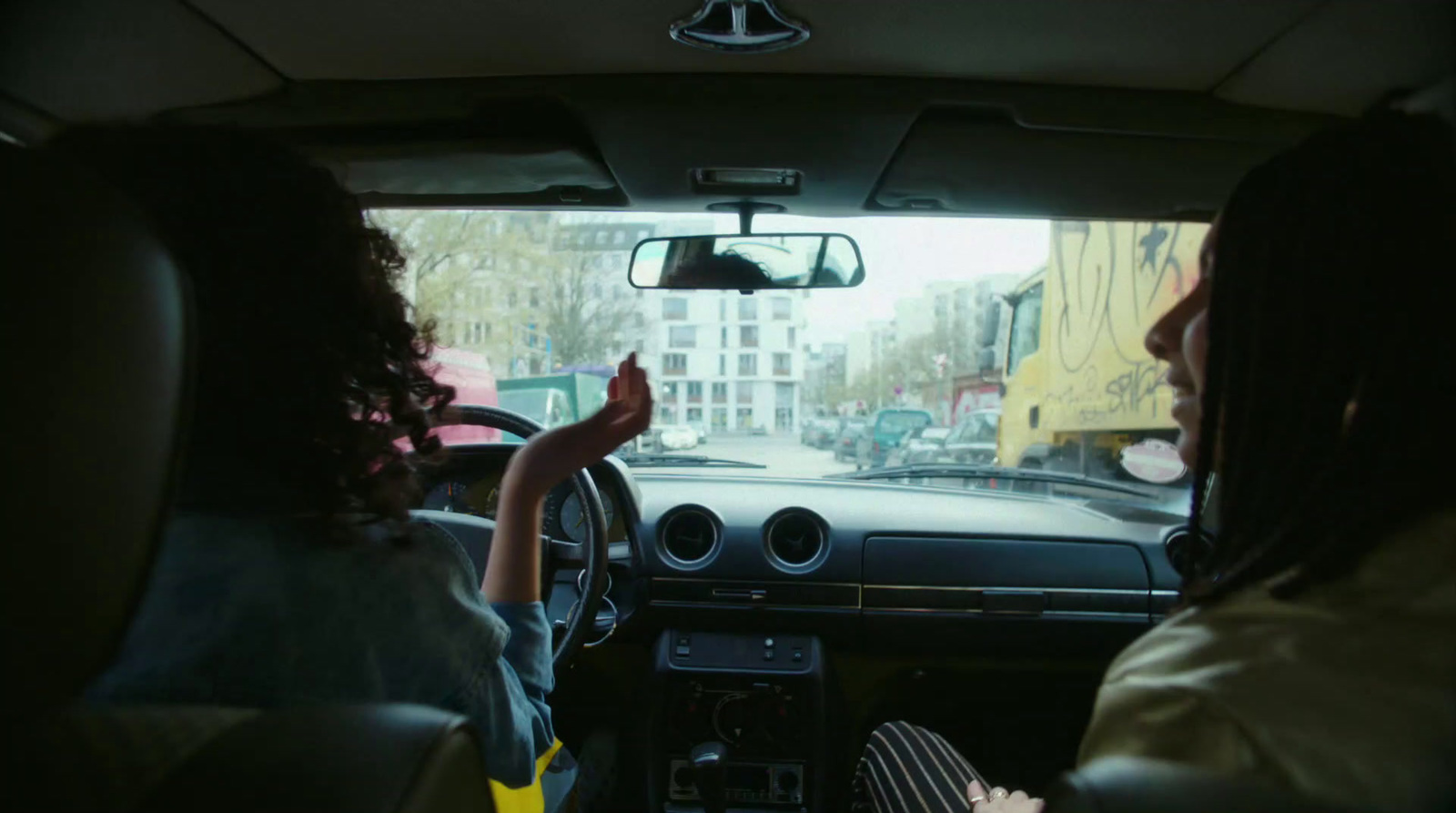 a woman driving a car with a child in the passenger seat