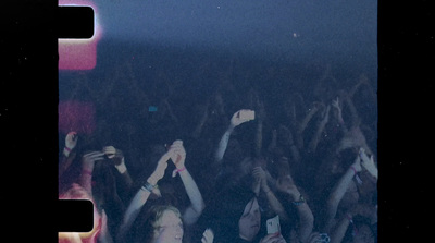 a crowd of people holding their hands up in the air