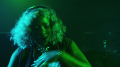 a woman playing a guitar in a dark room