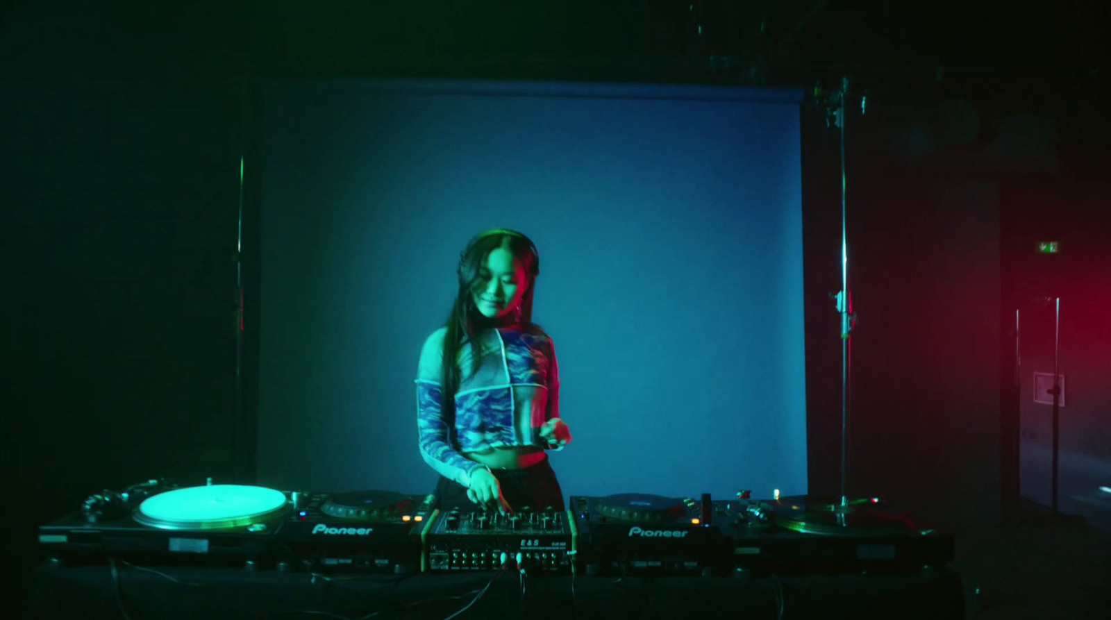 a woman standing in front of a dj set