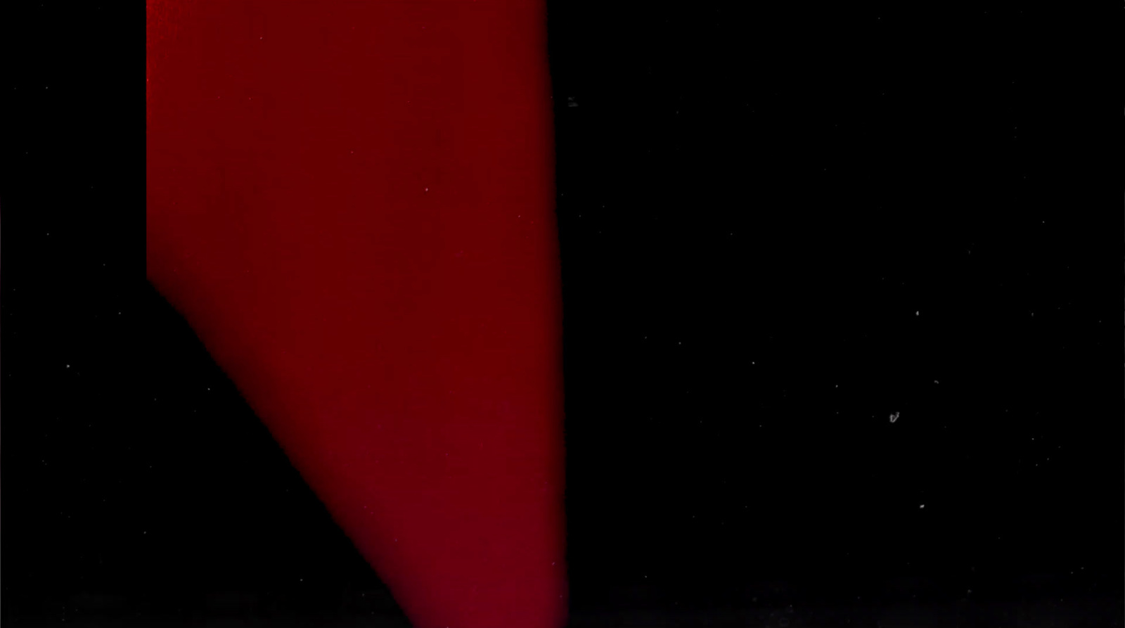 a close up of a red tie on a black background