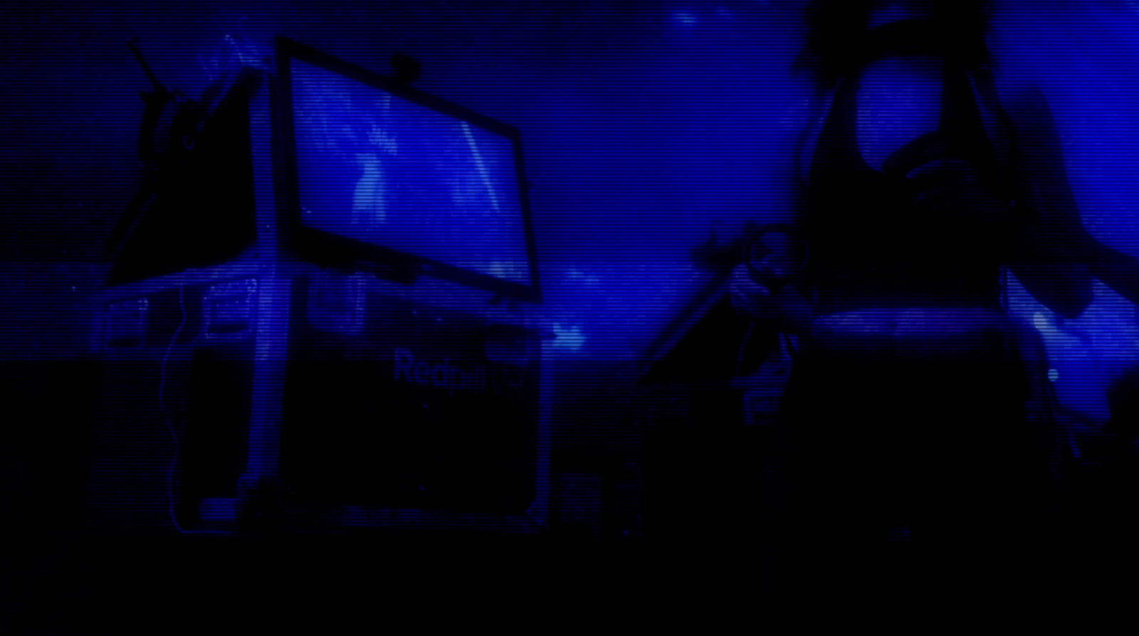 a dark room with a television and a blue screen