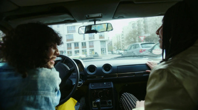 a man driving a car with a woman in the passenger seat