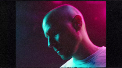 a man with a bald head in a dark room