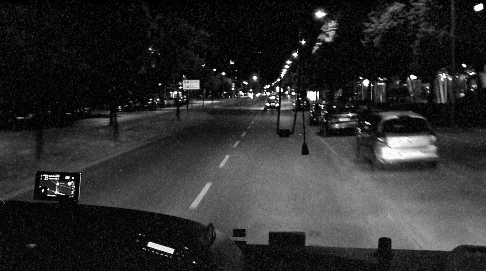 a car driving down a street at night