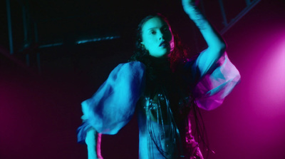 a woman standing on a stage with her arms in the air