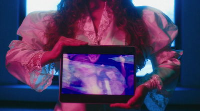 a woman in a pink dress holding a computer screen