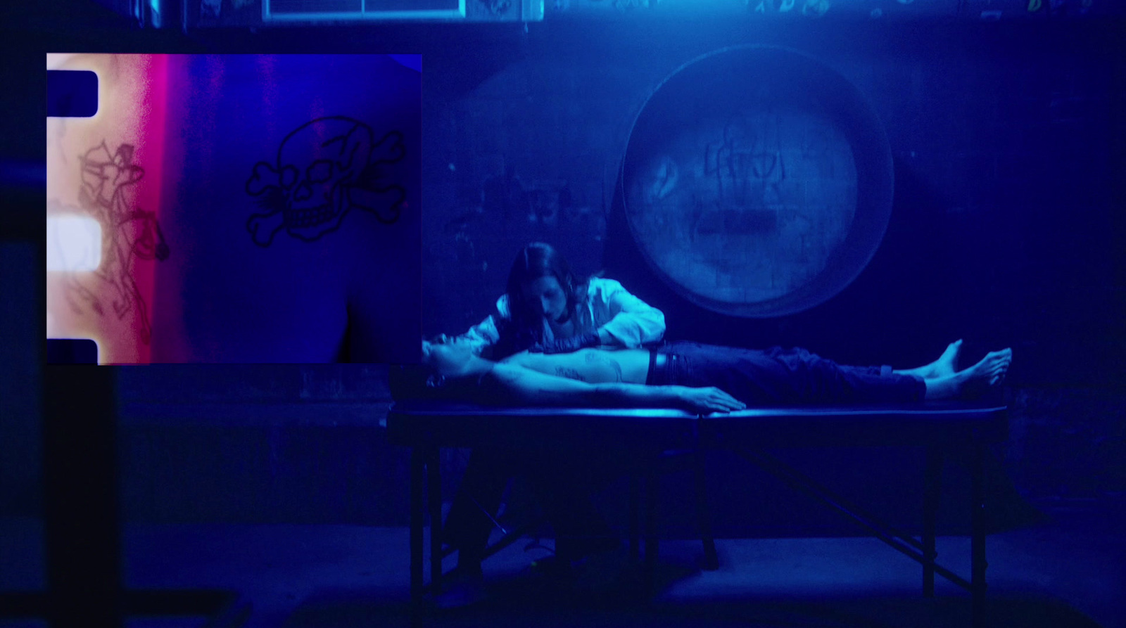 a man and a woman laying on a table in a dark room