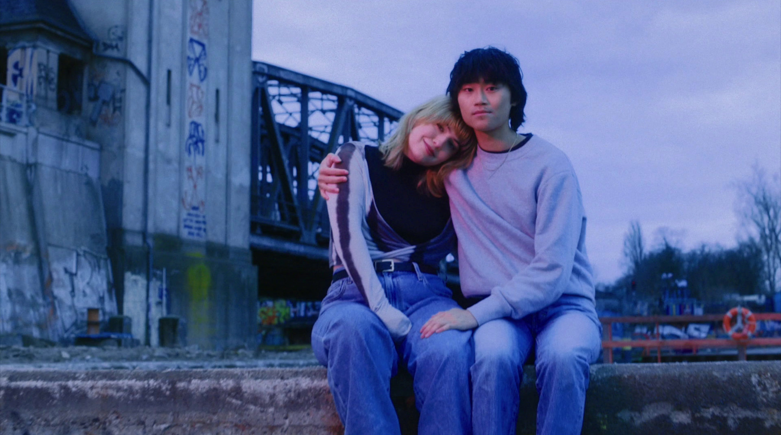 a man and a woman are sitting on a ledge