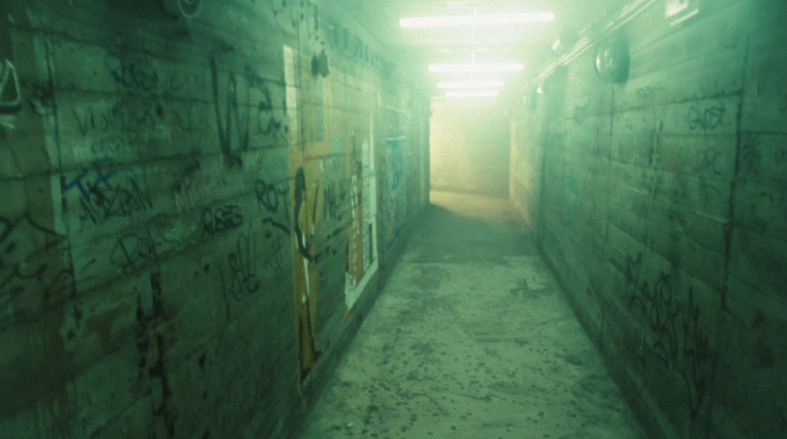 a long narrow hallway with graffiti on the walls